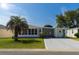 Inviting home with a well manicured lawn, carport, and a charming palm tree at 1220 Zapata Pl, Lady Lake, FL 32159