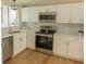 Contemporary kitchen with white cabinets, stainless steel appliances and updated countertops at 1220 Zapata Pl, Lady Lake, FL 32159