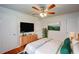 Bright bedroom with a ceiling fan, door to hall, and a dresser with flat screen TV for easy viewing at 14 Cyclops Dr, Apopka, FL 32703