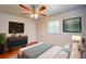 Bright bedroom featuring a ceiling fan, stylish dresser, mounted TV and a large window for natural light at 14 Cyclops Dr, Apopka, FL 32703