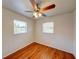 Neutral bedroom with wood-look floors, a ceiling fan, and bright natural light from two windows at 14 Cyclops Dr, Apopka, FL 32703