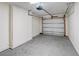 Empty, unfinished garage space featuring concrete floors, white walls, and a gray garage door at 14 Cyclops Dr, Apopka, FL 32703