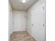 Bright laundry room with wood-look floors, shelving, and white doors for a clean and organized space at 14 Cyclops Dr, Apopka, FL 32703