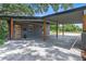 View of the carport with gray pavers, wooden posts, and dark gray painted support beams at 1401 Canberra Ave, Orlando, FL 32806