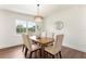 Bright dining room with a modern chandelier, wood table, and natural light from the window at 1401 Canberra Ave, Orlando, FL 32806