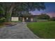 An exterior view of a gray home with a paver driveway, manicured lawn, and a covered entrance at 1401 Canberra Ave, Orlando, FL 32806