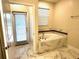 Bright bathroom featuring a large tub and marble-like tile at 1513 Maidstone Ct, Davenport, FL 33896