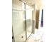 Modern bathroom features a glass-enclosed shower with tiled walls and patterned flooring at 1513 Maidstone Ct, Davenport, FL 33896