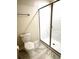 Modern bathroom featuring glass shower enclosure, toilet, and neutral color palette at 1513 Maidstone Ct, Davenport, FL 33896