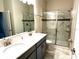 Modern bathroom with double sink vanity and tiled shower at 1513 Maidstone Ct, Davenport, FL 33896