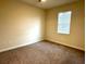 A bright bedroom offers neutral walls and carpet and a single, sun-filled window at 1513 Maidstone Ct, Davenport, FL 33896