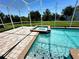 Beautiful screened-in pool and spa boasts serene backyard views and tiled deck at 1513 Maidstone Ct, Davenport, FL 33896