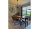 Dining room with a wooden table, modern chandelier, and a large window overlooking the yard at 15708 Orange Harvest Loop, Winter Garden, FL 34787