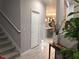 Hallway with staircase, a table with vase, plants and view into the kitchen with breakfast bar seating at 15708 Orange Harvest Loop, Winter Garden, FL 34787