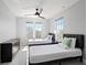 Well-lit bedroom featuring two twin beds, ceiling fan, and a view of the neighborhood at 166 Minniehaha Cir, Haines City, FL 33844