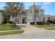 Beautiful two-story home with lush green lawn, driveway and mature trees at 166 Minniehaha Cir, Haines City, FL 33844