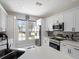 Modern kitchen with sleek white cabinets, stainless steel appliances, and abundant natural light at 166 Minniehaha Cir, Haines City, FL 33844