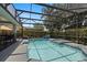 A screened-in pool area featuring a swimming pool with lounge chairs and a view of the backyard at 166 Minniehaha Cir, Haines City, FL 33844