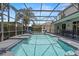 A screened-in pool and patio area with outdoor furniture and lush landscaping at 166 Minniehaha Cir, Haines City, FL 33844
