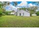 Spacious backyard featuring a lush lawn, a charming fire pit area, and a white exterior at 1800 Silver Valley Ct, Apopka, FL 32712