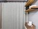 Bathroom featuring a shower with curtain, wooden shelving, and wicker basket for storage at 1803 Foxhall Cir # 1803, Kissimmee, FL 34741