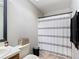 Bathroom features a shower with curtain, toilet and sink with wood cabinets at 1803 Foxhall Cir # 1803, Kissimmee, FL 34741