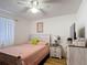 Bedroom featuring light walls and wood floors, including a window and ceiling fan at 1803 Foxhall Cir # 1803, Kissimmee, FL 34741