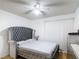 Bedroom boasts a tufted headboard, white ceiling fan and light colored wood flooring at 1803 Foxhall Cir # 1803, Kissimmee, FL 34741