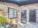 Close-up of the brick exterior with dual front doors, complemented by charming potted plants and a window at 1803 Foxhall Cir # 1803, Kissimmee, FL 34741
