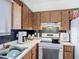 Bright kitchen features wood cabinets, an electric range, and a stainless steel sink at 1803 Foxhall Cir # 1803, Kissimmee, FL 34741