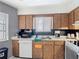 Well-equipped kitchen featuring essential appliances, wood cabinetry, and bright countertops at 1803 Foxhall Cir # 1803, Kissimmee, FL 34741