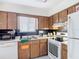 Efficient kitchen with wood cabinets, white appliances, and ample counter space for meal preparation at 1803 Foxhall Cir # 1803, Kissimmee, FL 34741