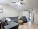 Spacious living room with vaulted ceiling, tiled floors, a ceiling fan, and a large gray sectional at 1803 Foxhall Cir # 1803, Kissimmee, FL 34741