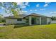 Backyard view of the home's covered patio, windows and a lush green lawn at 19073 Sabal St, Orlando, FL 32833