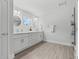Modern bathroom with double vanity, decorative mirrors, a window, and a glass-enclosed shower at 19073 Sabal St, Orlando, FL 32833