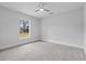 This bedroom has plush grey carpeting, a ceiling fan and a view through the window at 19073 Sabal St, Orlando, FL 32833