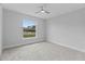 This bedroom has plush grey carpeting, a ceiling fan and a view through the window at 19073 Sabal St, Orlando, FL 32833
