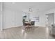 A stylish dining room features gray chairs, a modern ceiling fan, and neutral decor, adjacent to the open-concept living space at 19073 Sabal St, Orlando, FL 32833