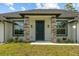 Inviting entryway featuring stone column accents, a dark front door, and beautifully landscaped greenery at 19073 Sabal St, Orlando, FL 32833