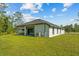 Rear exterior of the home showcasing a well-manicured lawn, covered patio, and modern architectural details at 19073 Sabal St, Orlando, FL 32833