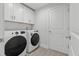 Bright laundry room featuring modern white appliances and upper cabinets for storage, perfect for efficient home management at 19073 Sabal St, Orlando, FL 32833