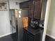 Kitchen showcasing modern stainless steel refrigerator and black countertops, with mosaic backsplash and brown cabinets at 1950 Summer Club Dr # 202, Oviedo, FL 32765