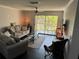 Bright living room with modern ceiling fan, neutral walls, and sliding glass doors to a balcony at 1950 Summer Club Dr # 202, Oviedo, FL 32765