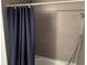 Shower stall with grey tiled walls and a navy blue waffle patterned shower curtain at 1950 Summer Club Dr # 202, Oviedo, FL 32765