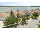 Aerial view of single Gathering home by the lake with lush, mature trees and landscaping at 259 Blue Cypress Dr, Groveland, FL 34736