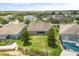 Aerial view of backyard with screened in pool and lush lawn in residential neighborhood at 259 Blue Cypress Dr, Groveland, FL 34736