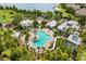 A community pool featuring a waterslide, palm trees, and ample seating, all surrounded by lush landscaping and serene lake views at 259 Blue Cypress Dr, Groveland, FL 34736