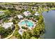 An aerial view showcasing a community pool with a waterslide, surrounded by lush greenery and lakeside scenery at 259 Blue Cypress Dr, Groveland, FL 34736