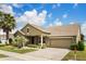 Inviting single-Gathering home featuring lush landscaping, a well-maintained lawn, and a two-car garage at 259 Blue Cypress Dr, Groveland, FL 34736