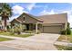 Charming single Gathering home with a well-manicured lawn, mature palm trees, and a two-car garage at 259 Blue Cypress Dr, Groveland, FL 34736